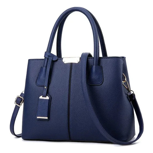 Elegant dark blue leather handbag with dual handles and adjustable shoulder strap