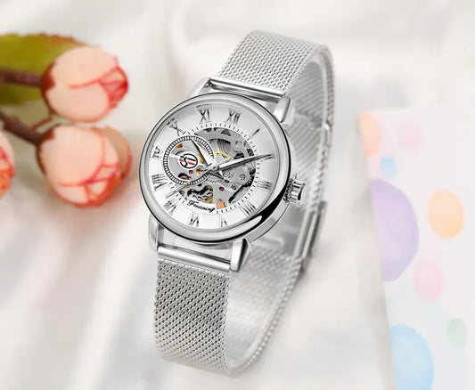 Silver mesh band skeleton watch with Roman numerals on soft background, elegant fashion accessory