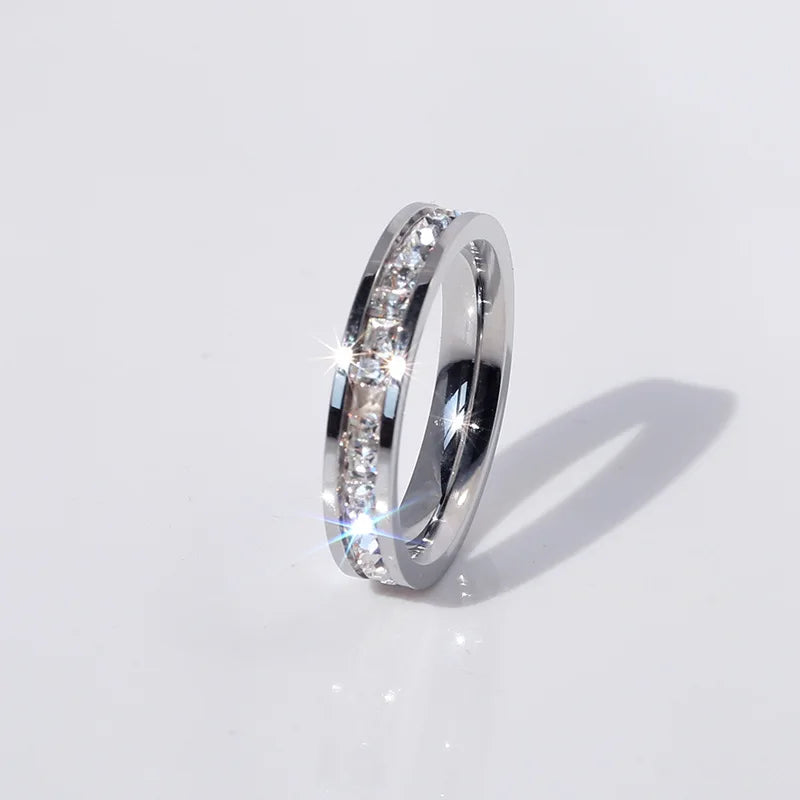 Silver band ring with sparkling clear stones inlay, elegant jewelry on white background