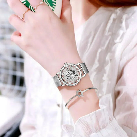 Women's silver mesh band skeleton watch and star bracelet on wrist