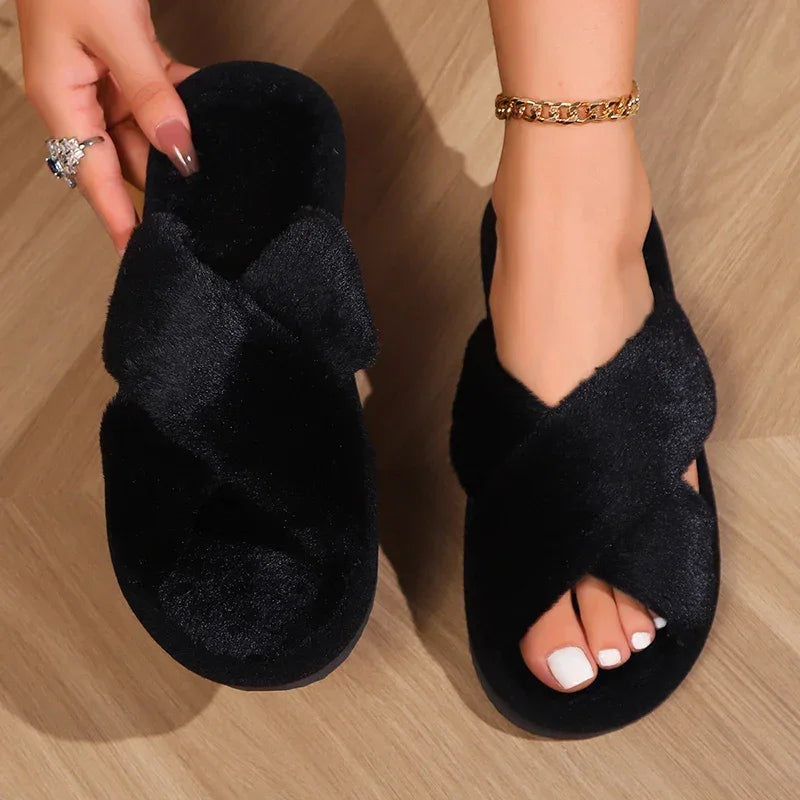 Black fuzzy cross-strap slippers on wood floor, stylish footwear from danastors fashion shop