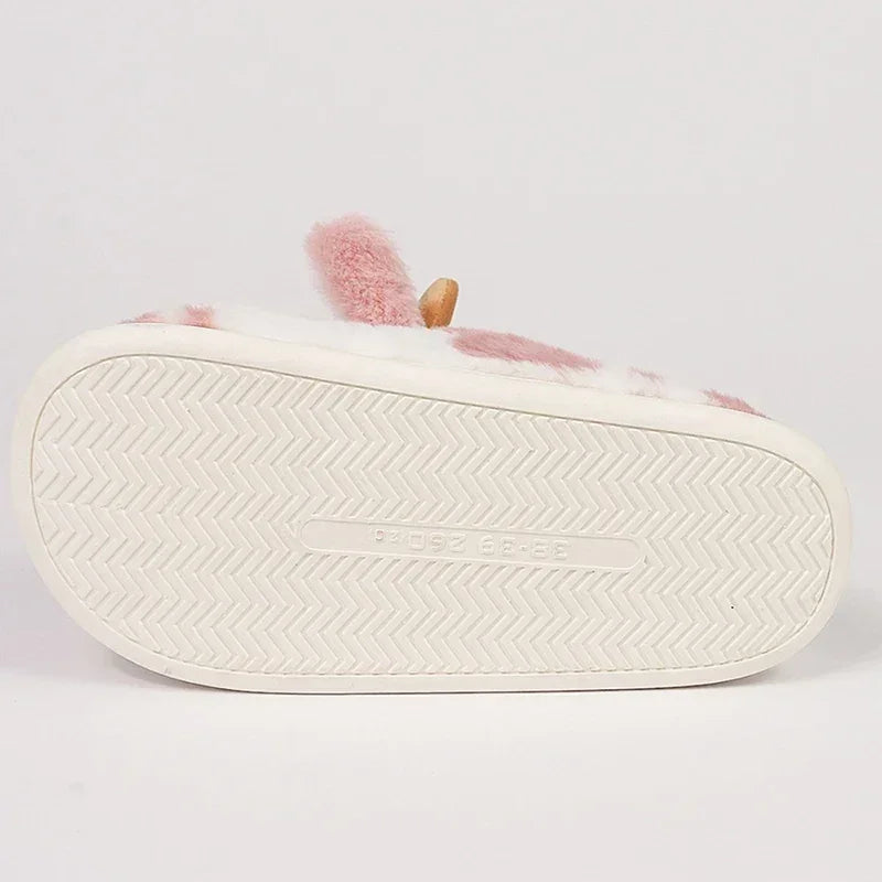 Bottom view of a plush pink and white slipper with textured non-slip sole