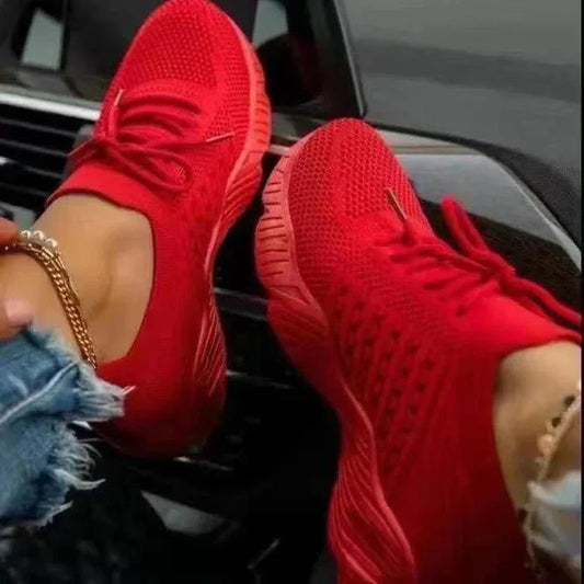 Bright red mesh sneakers on woman wearing gold anklet and ripped jeans, danastors fashion