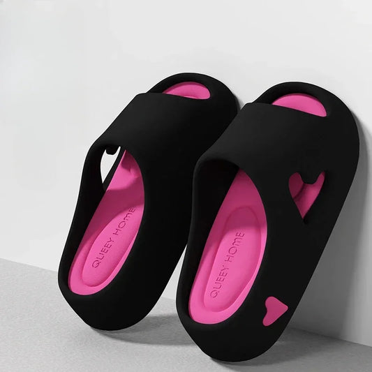 Black and pink open-toe slippers with heart cutouts, modern casual footwear on light background
