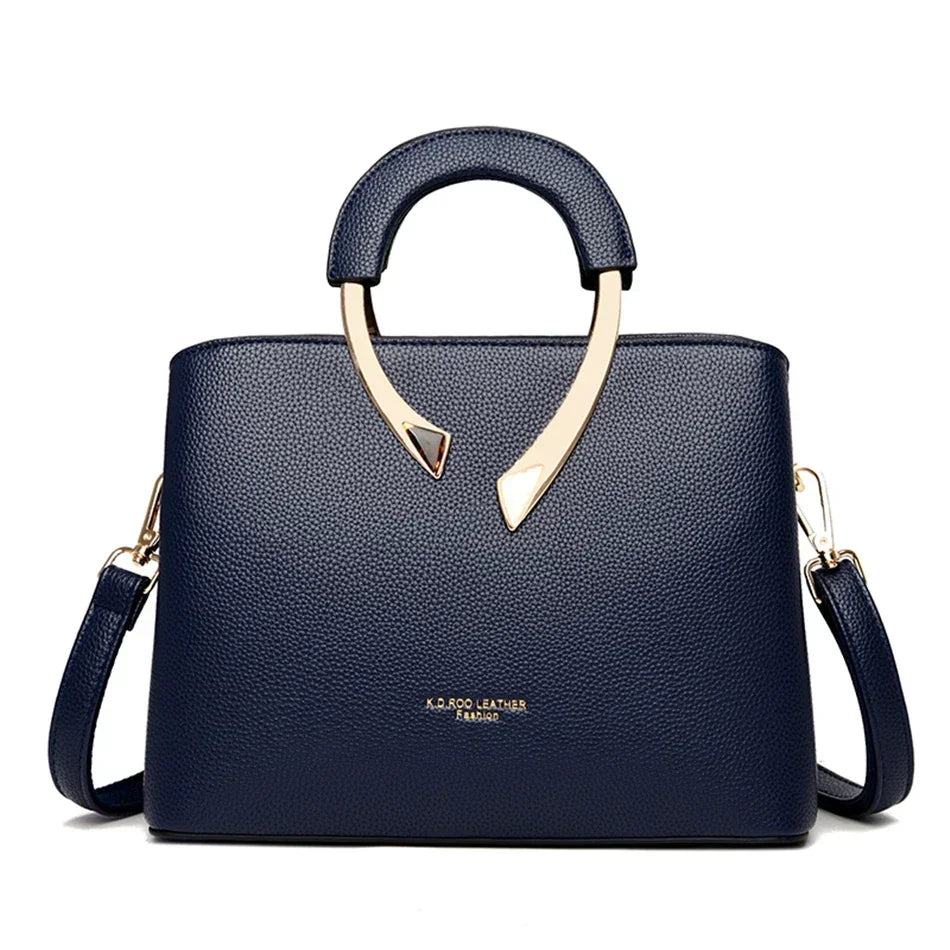 Elegant navy blue leather handbag with gold metallic handles and detachable shoulder strap