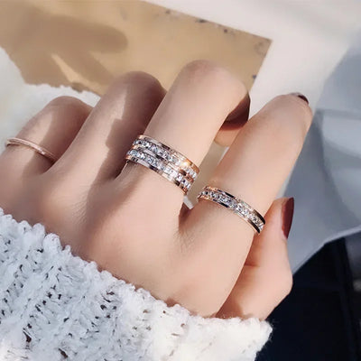 Woman's hand wearing stacked crystal band rings, elegant fashion jewelry style