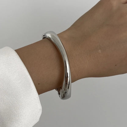 Minimalist silver cuff bracelet on wrist, modern jewelry fashion accessory