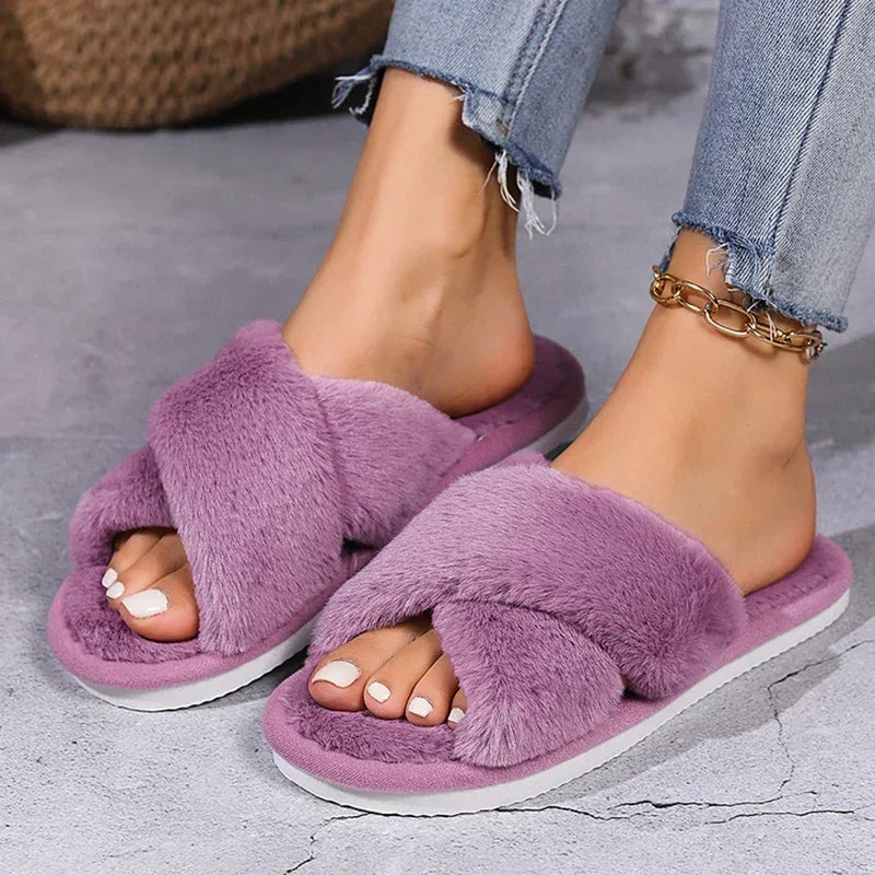 Purple faux fur cross band slippers on feet, paired with light denim jeans and anklet