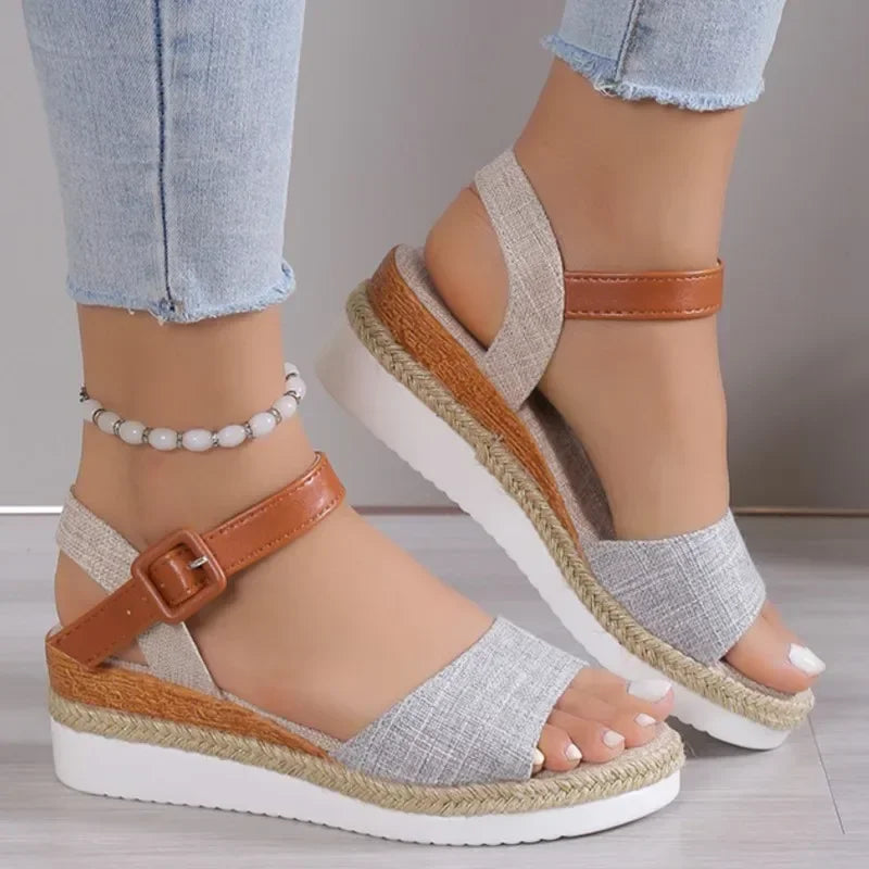 Women's wedge sandals with gray fabric straps, brown buckle, and espadrille platform soles
